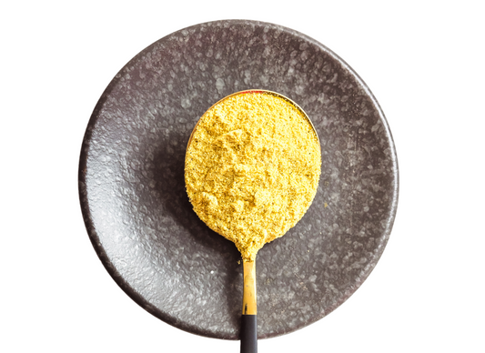 Spoonful of yellow powder on a dark plate