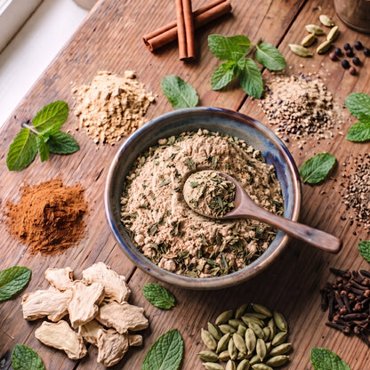 T2GO Mint Chai Masala in a bowl surrounded by cinnamon, cardamom, cloves, ginger and fresh mint