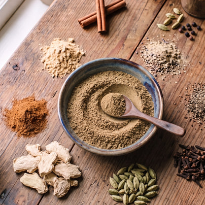 T2GO Original Chai Masala in a bowl surrounded by cinnamon, star anise, cardamom, cloves and ginger