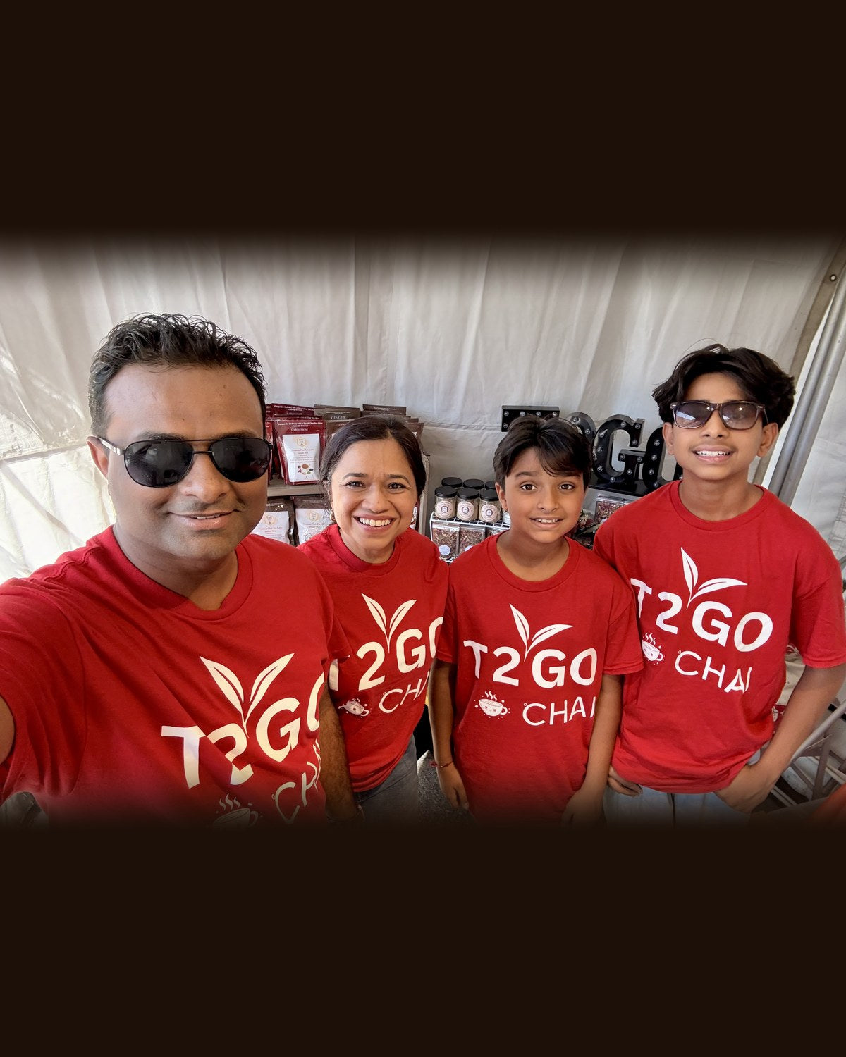 T2GO Chai founder Minal Mehta with her husband and two sons in matching red T2GO Chai shirts